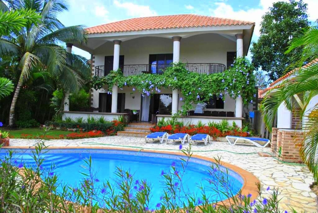 a house with a swimming pool in front of it at Villa Metro Country Club in Juan Dolio