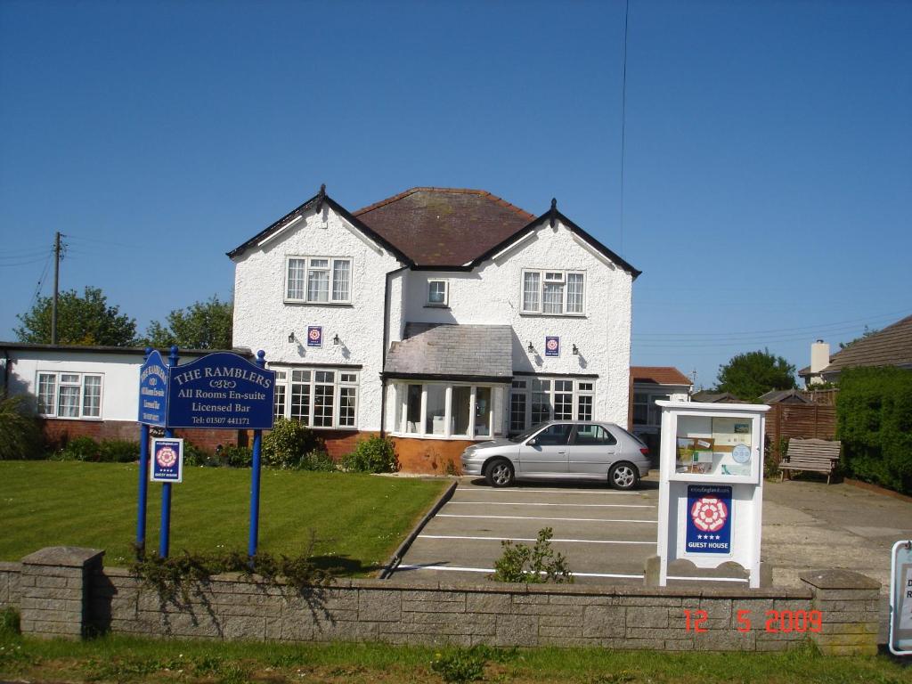 a white house with a car parked in front of it at The Ramblers in Trusthorpe