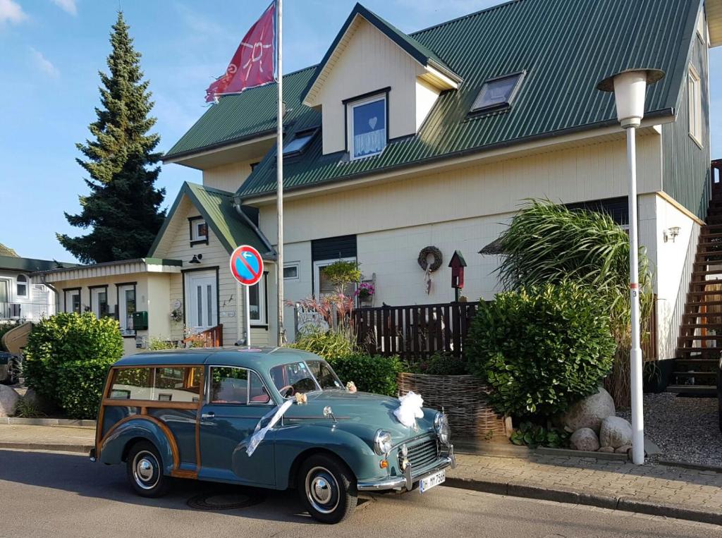 an old blue car parked in front of a house at Gästehaus Alwine Wohnung 6 in Grömitz