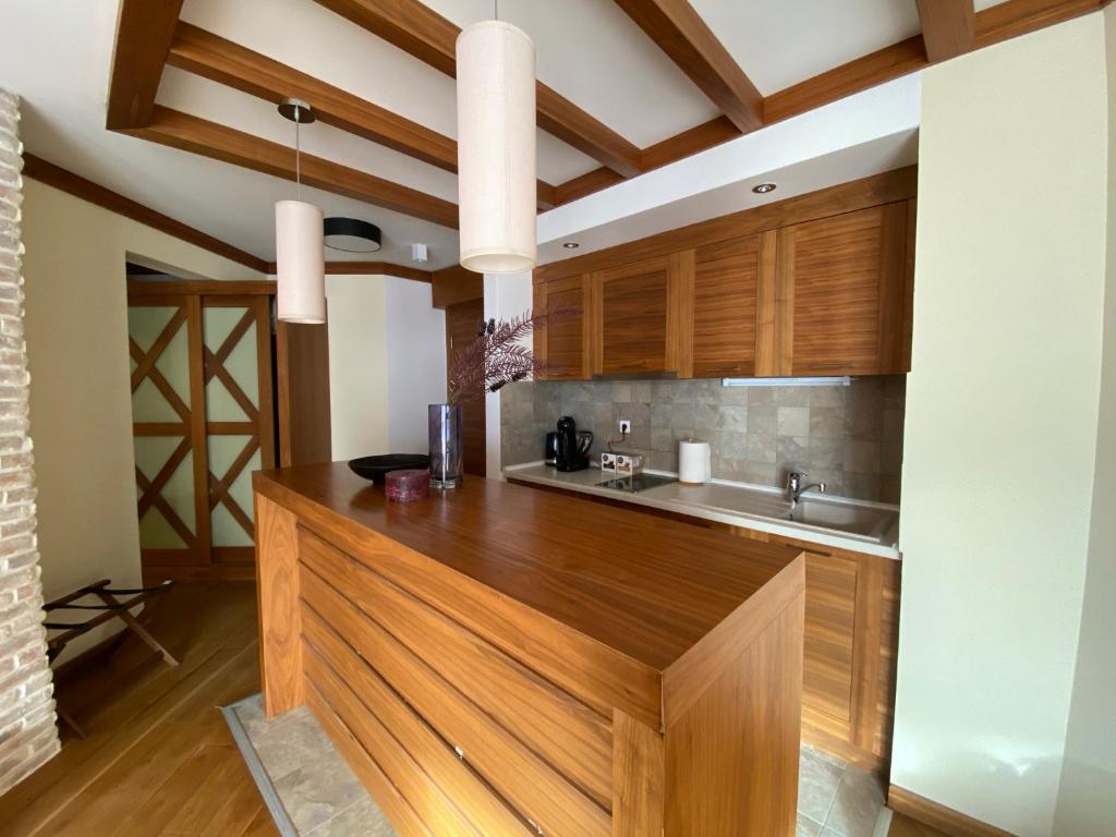 uma cozinha com armários de madeira e um lavatório em LUX apartman B432 u Aparthotelu Vučko em Jahorina