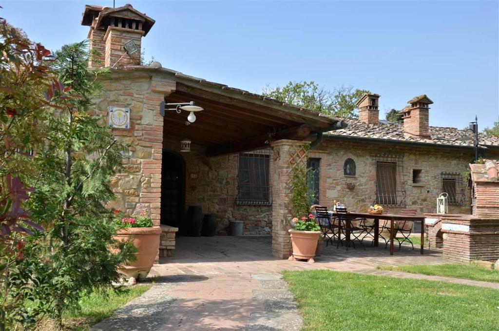 Casa de piedra con patio y mesa en Il Casolare, en Gambassi Terme