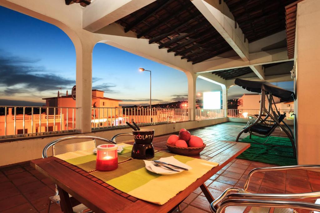 a table and chairs on a balcony with a view at Guest House Oliveira in Boliqueime