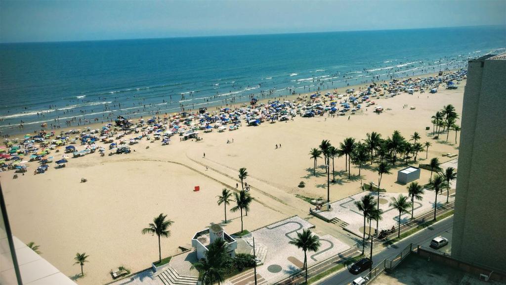 a beach with a lot of umbrellas and the ocean at Apto do Ronaldo vila Guilhermina in Praia Grande