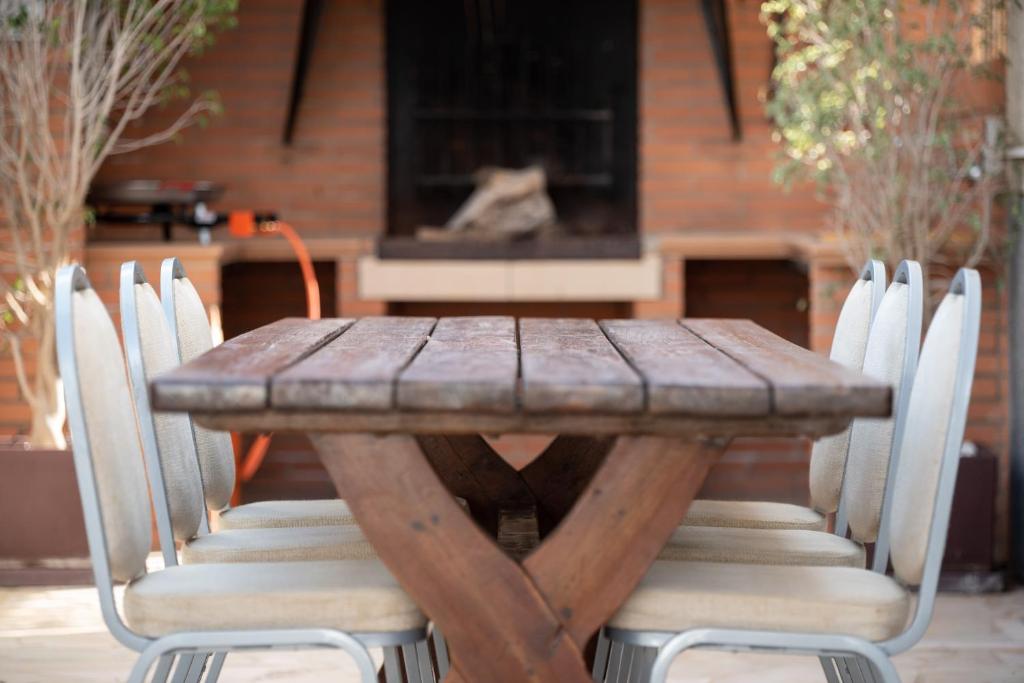 una mesa de madera con sillas blancas alrededor en Casa Riu Avall en Riumar