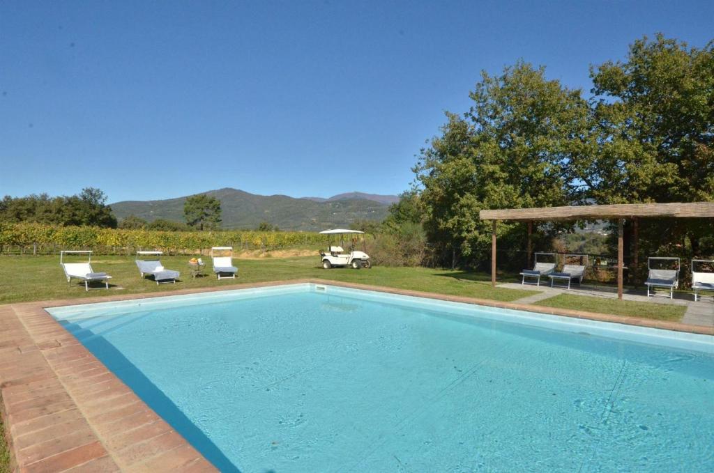 einen Pool mit Stühlen und einem Pavillon in der Unterkunft Villa dei Cavalli in Arezzo