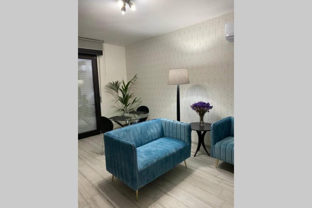 a living room with two blue chairs and a table at Nuovo appartamento Elegante,curato nei dettagli in Decimomannu