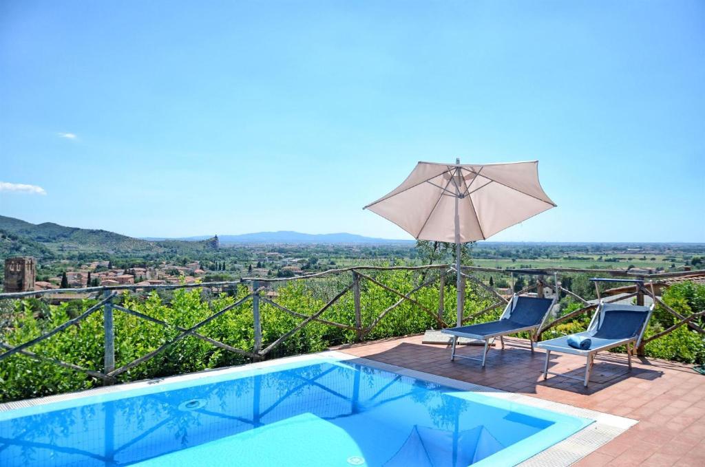 una piscina con 2 sillas y una sombrilla en Oleandro, en Calci