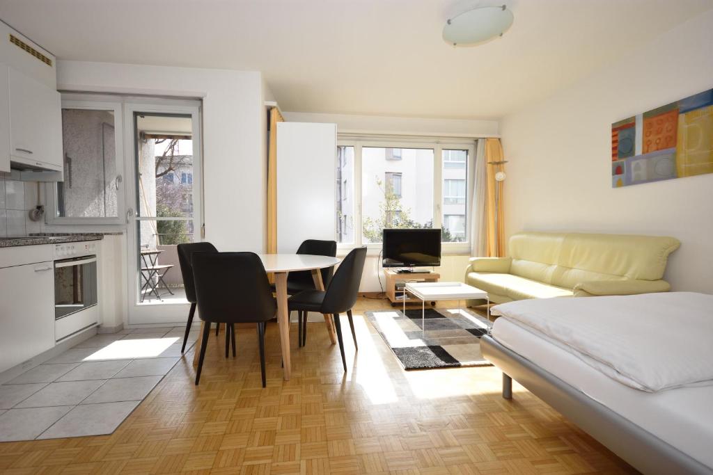 sala de estar con cama, mesa y sillas en PABS Résidences - Weinbergstrasse 68 (2ML), en Zúrich