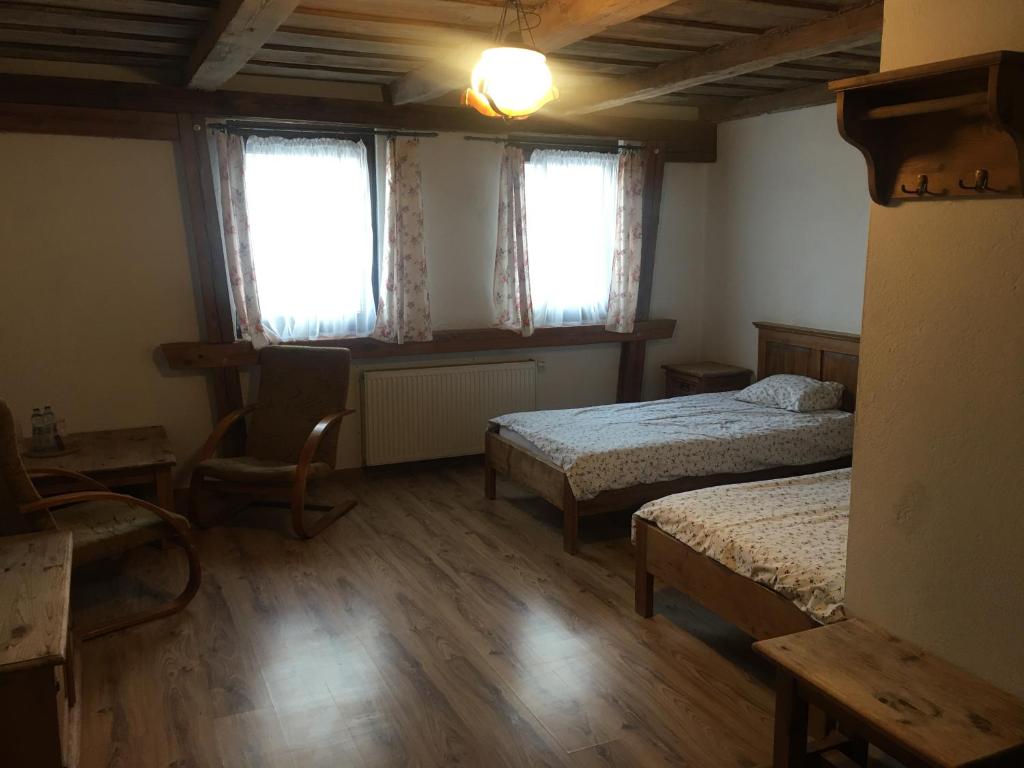 een slaapkamer met 2 bedden en 2 ramen bij Pensjonat Stary Spichlerz in Ełk