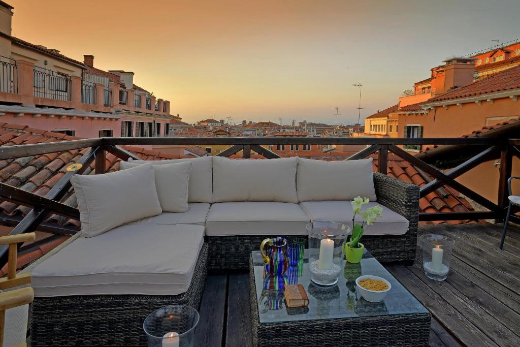a couch sitting on a balcony with a table at Palazzo Ca'nova on the Grand Canal - Canella Apartment in Venice