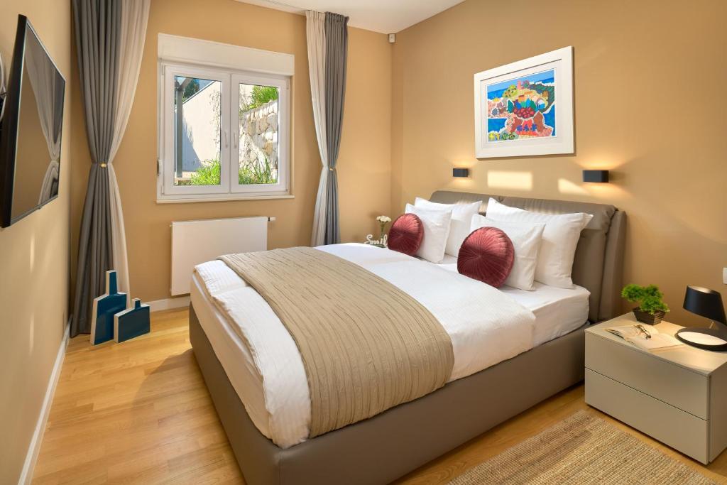 a bedroom with a large bed and two windows at Sun Spalato Hills in Split