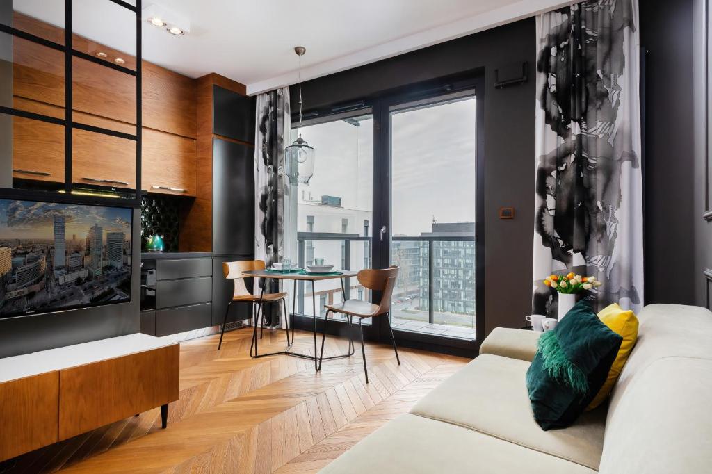 a living room with a couch and a table at Apartments Konstruktorska by Renters Prestige in Warsaw