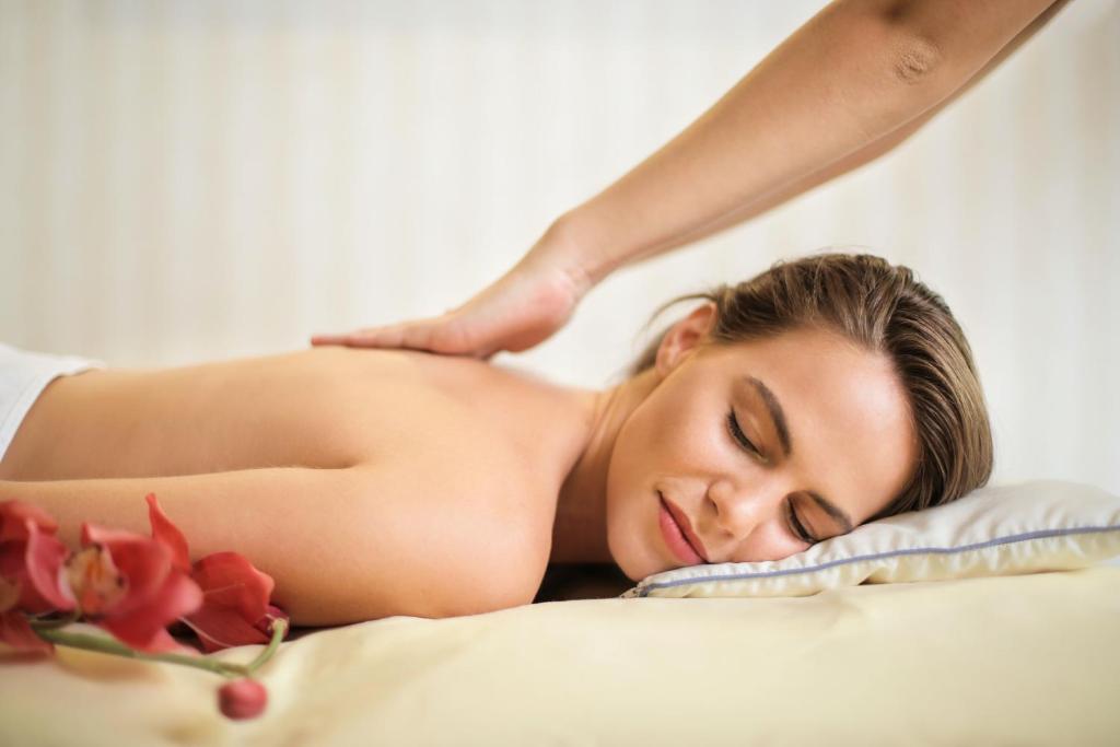 a woman laying on a bed getting a massage at Hostel Hof Kranichstein in Kluis