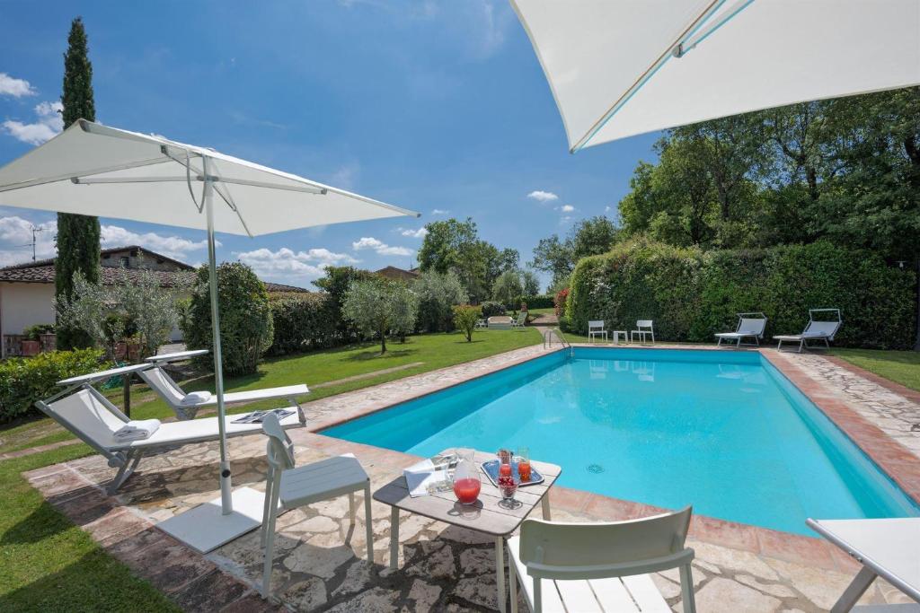 - Piscina con mesa y sombrilla en Poggio della Villa, en Radda in Chianti