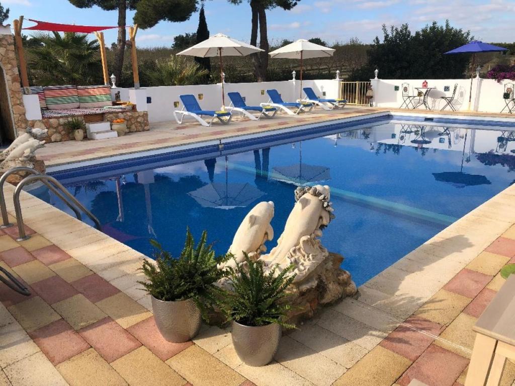 a swimming pool with a statue in the middle of it at LEMON TREE VILLA in Monserrat