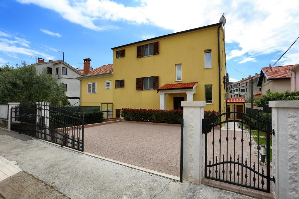 una casa amarilla con puerta y entrada en Apartments Ivana - Iva, en Zadar