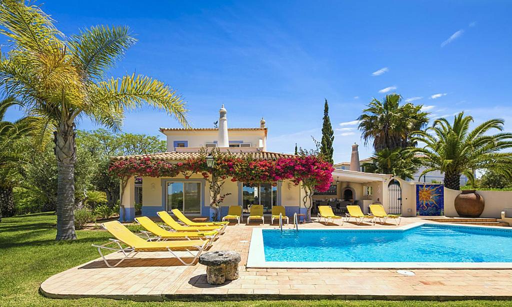 カルヴォエイロにある4 bedrooms villa with city view private pool and enclosed garden at Carvoeiro 2 km away from the beachの椅子付きスイミングプールのある家