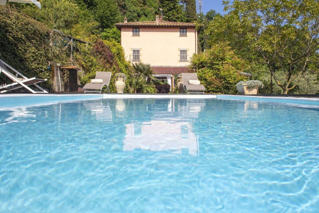 una gran piscina con una casa en el fondo en Villa Giovannino, en Camaiore