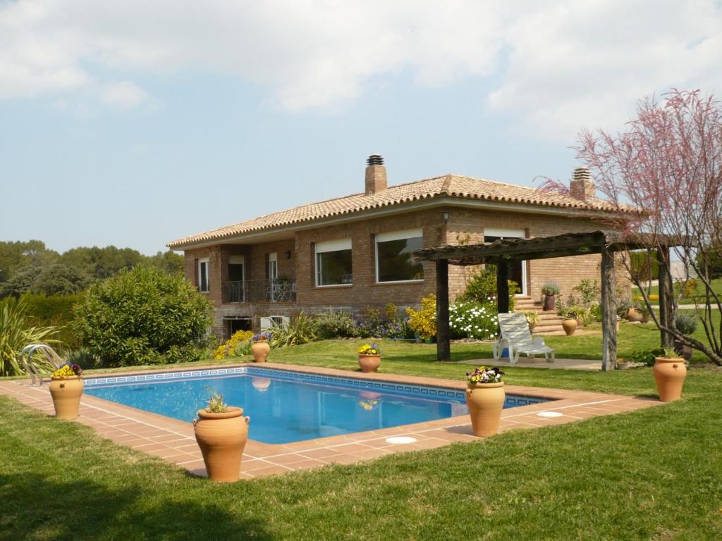 une maison avec une piscine dans la cour dans l'établissement Villa La Romaguera, à Garrigolas