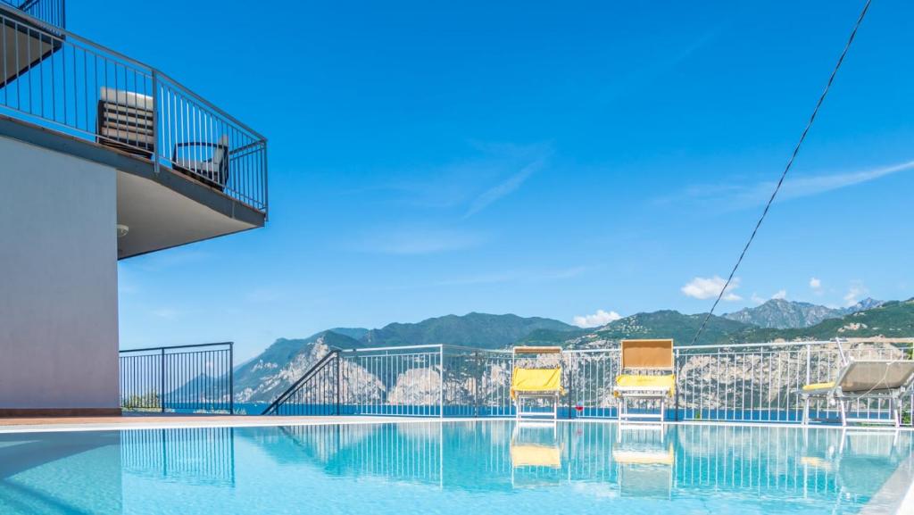 eine Gruppe von Stühlen auf einem Pool in der Unterkunft Hotel Casa Marinella in Malcesine