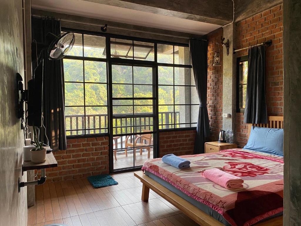 ein Schlafzimmer mit einem Bett und einem großen Fenster in der Unterkunft PilokMyhome ที่พักเหมืองปิล็อก บ้านอีต่อง in Ban Pilok Khi
