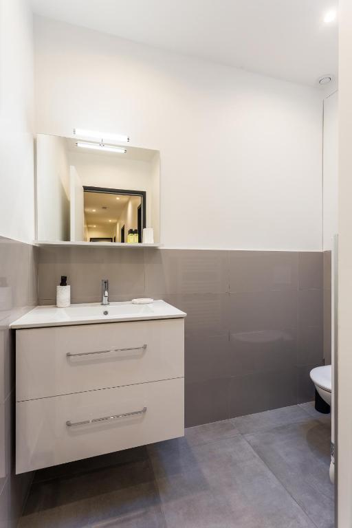 a bathroom with a white sink and a toilet at CMG - Champs Elysées Boetie 4DF in Paris