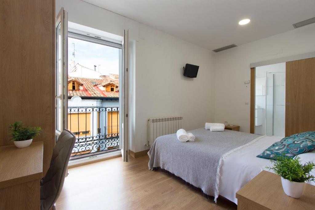 a bedroom with a bed and a large window at Hostal La Numantina in Logroño