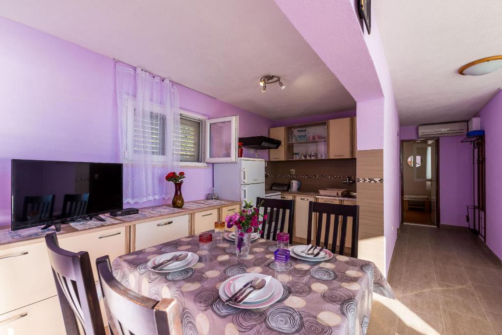 a purple kitchen with a table with plates on it at Apartment Angelina in Dubrovnik