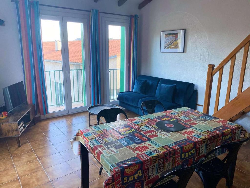 un salon avec une table et un canapé bleu dans l'établissement 4MIR11BLEU - Appartement pour 4 personnes T2 en duplex tout confort, à Collioure