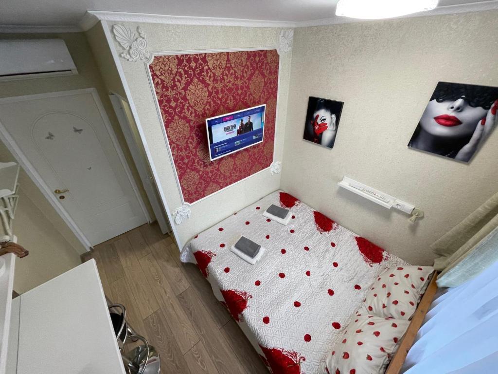 a small bedroom with a bed with a red head board at Hostel V Tapochkakh in Kazan