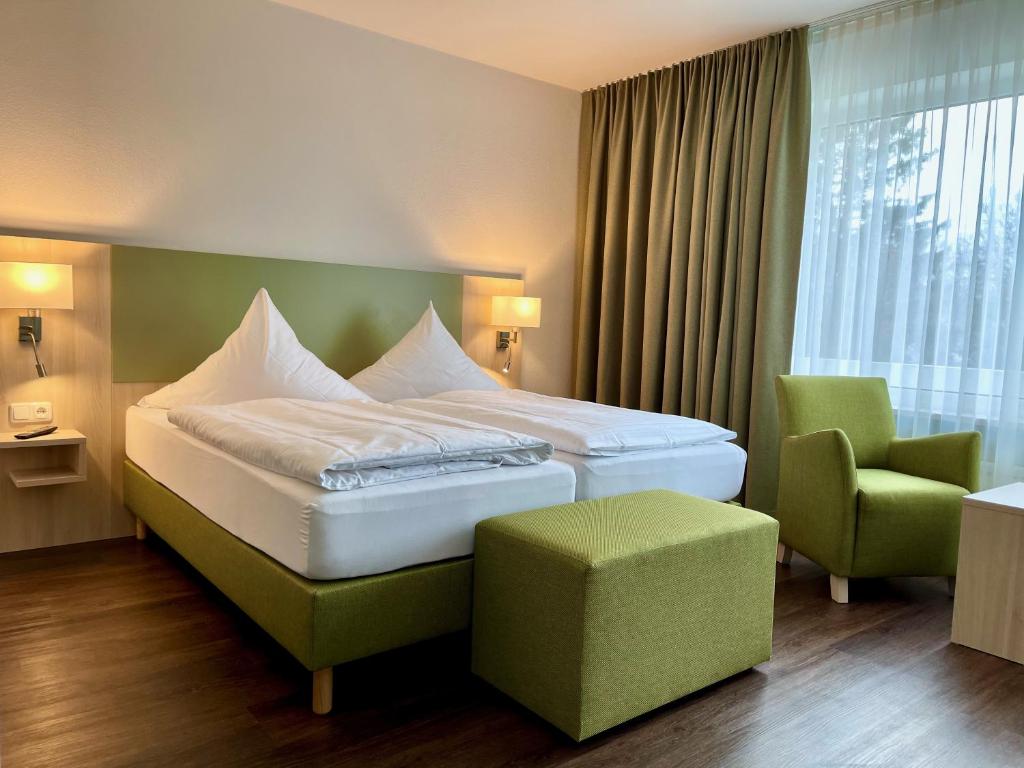 a hotel room with a bed and a chair at Marias Inn - Bed & Breakfast in Garching bei München