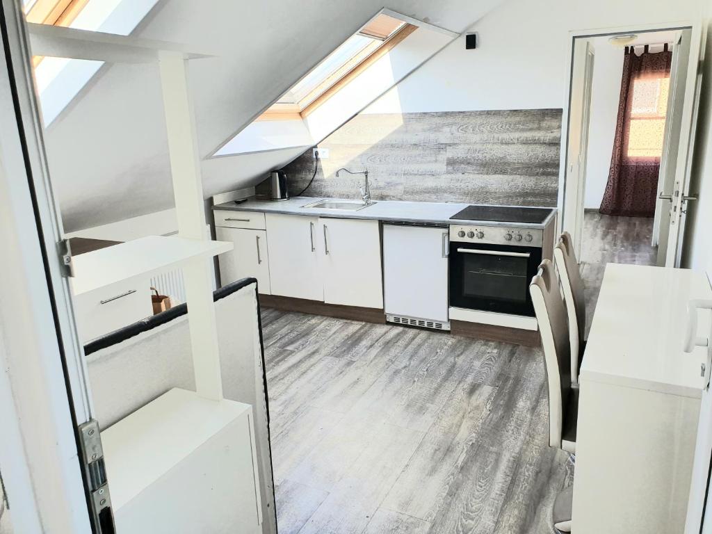 uma cozinha com armários brancos e um forno com placa de fogão em FMI Apartment LST Next to Airport em Rüsselsheim
