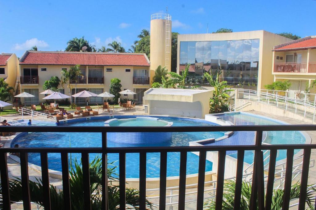 uma vista para a piscina a partir da varanda de um hotel em Solar Água Pipa #260 - Apê na Praia por Carpediem em Pipa