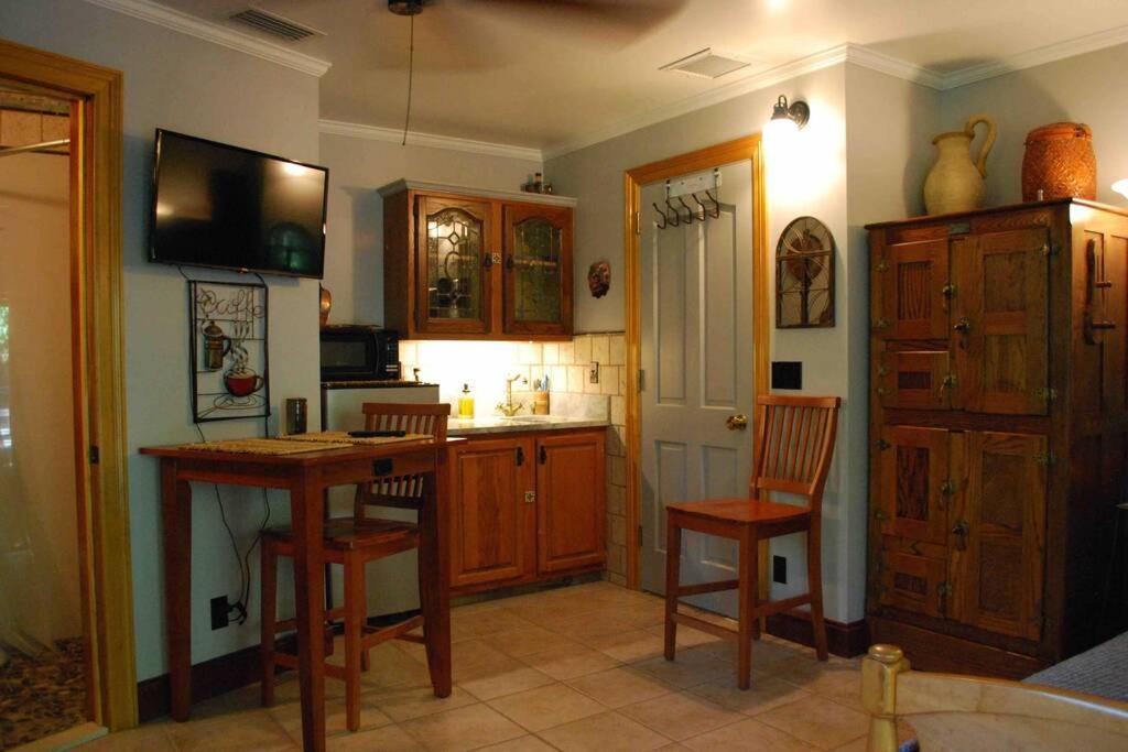 - une cuisine avec des placards en bois, une table et des chaises dans l'établissement Quiet Private Studio with Pool for One Guest, à Lake Worth