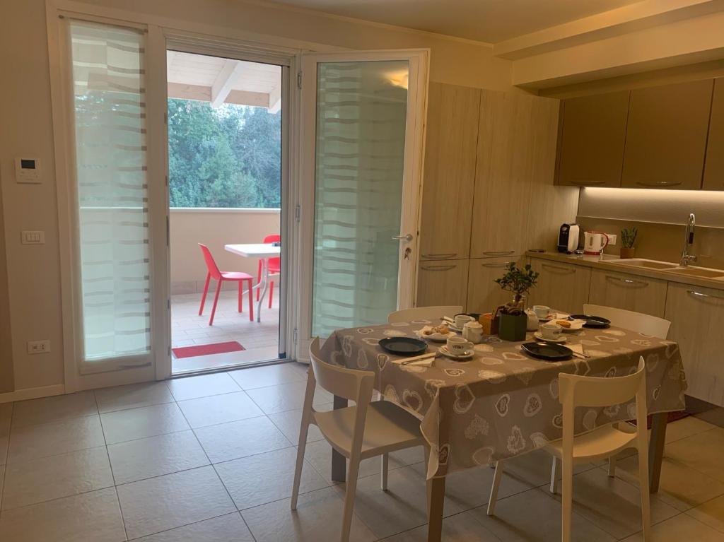 eine Küche mit einem Tisch, Stühlen, einem Tisch und einem Tisch sowie einer Küche in der Unterkunft Le Noir appartment in Peschiera del Garda