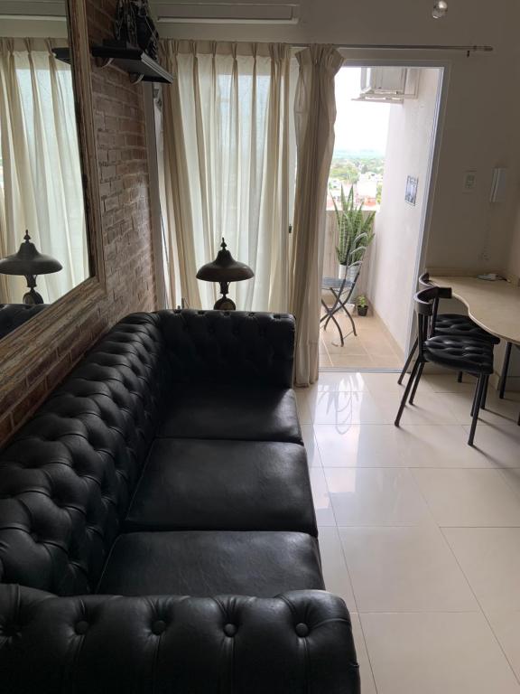 a black leather couch sitting in a living room at Hermoso departamento un dormitorio in Santa Fe