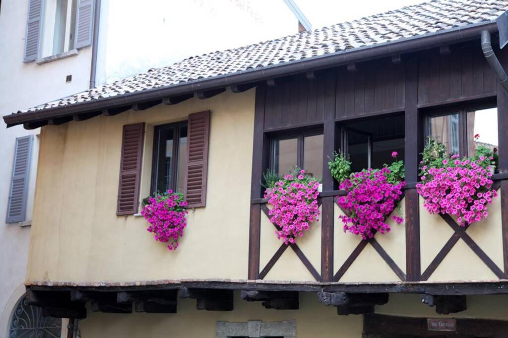 a building with pink flowers on a balcony at Alla Piazzetta del Castello in Cernobbio