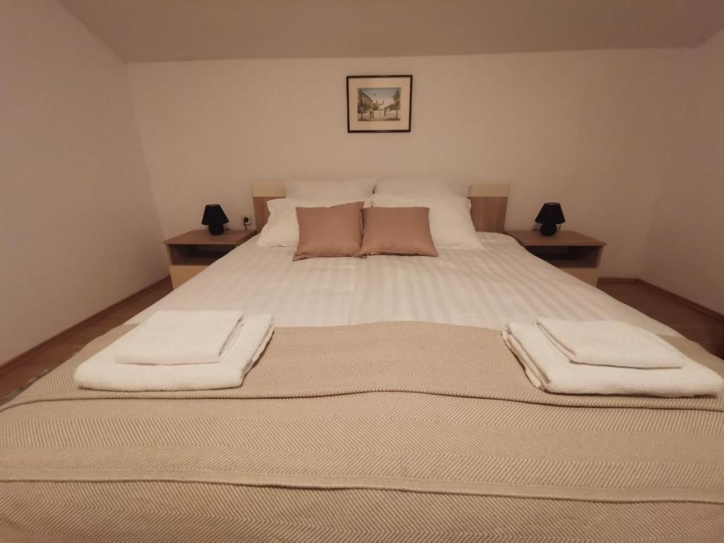 a bedroom with a large bed with two towels on it at Baka Ljuba 
