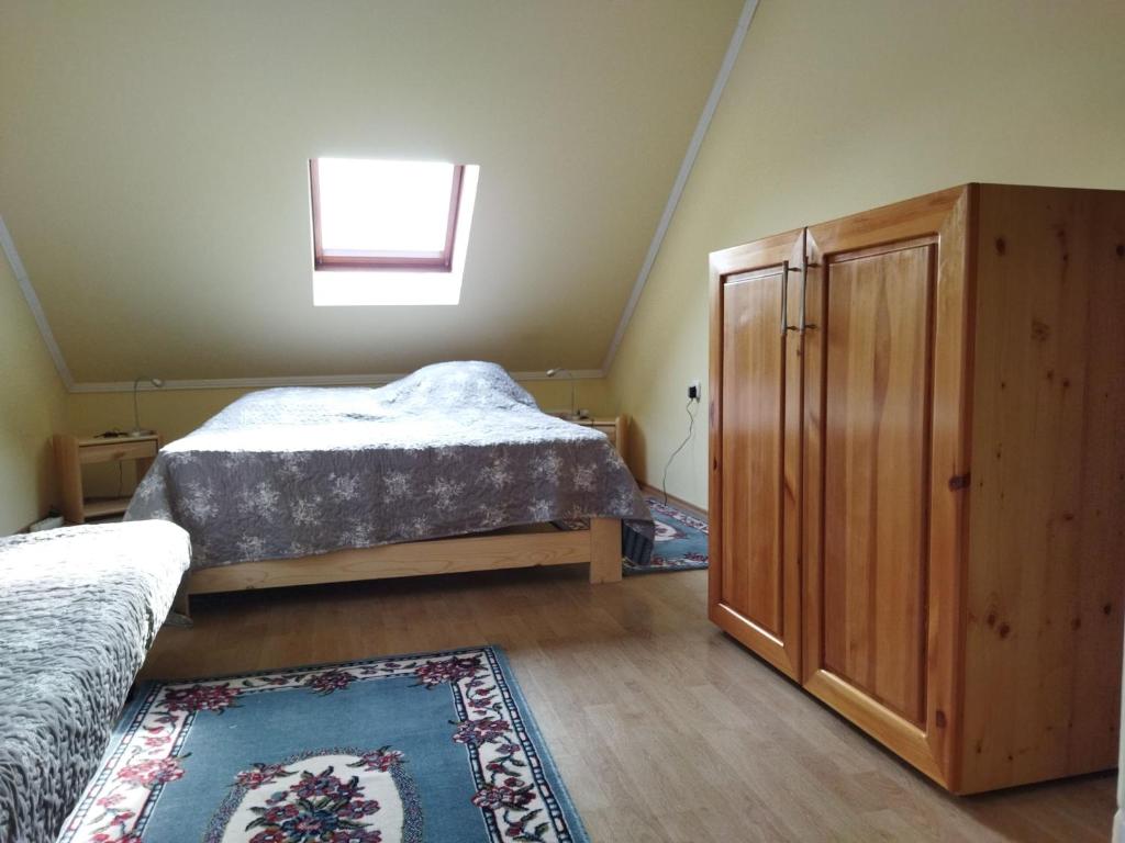 1 dormitorio con 2 camas, armario y alfombra en Naszály Kapuja vendégház, en Kosd