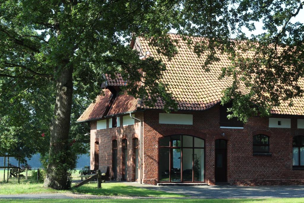 a brick house with a tree in front of it at Ferienhaus auf Gut Sautmannshausen in Haselünne