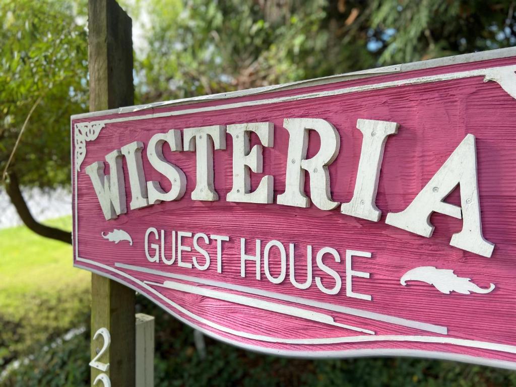a wooden sign for a guest house at Wisteria Guest House in Ganges