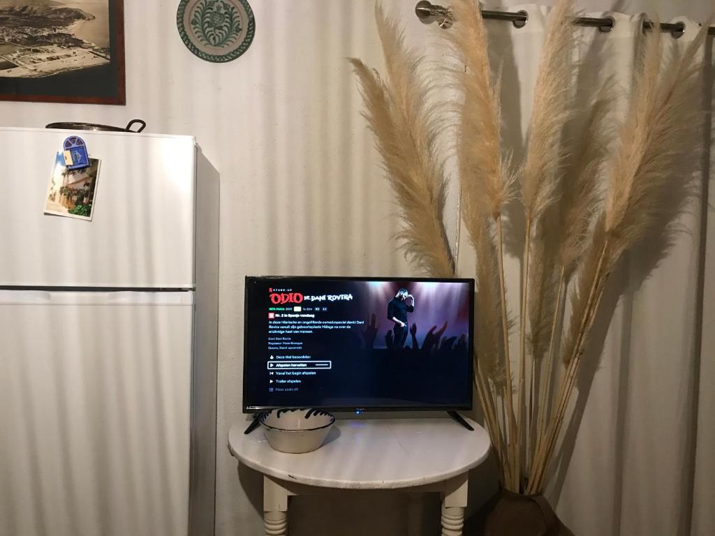een computermonitor op een tafel naast een koelkast bij Cortijo el Abejaruco in Almuñécar