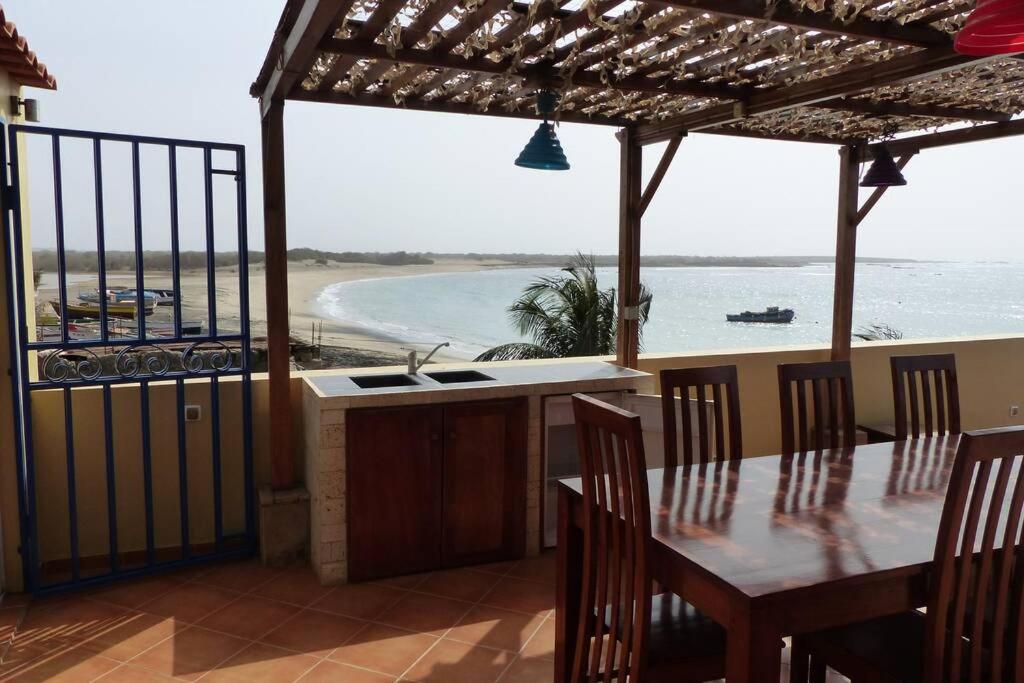 a kitchen with a table and a view of the ocean at Calheta - Casa Amarela in Calheta