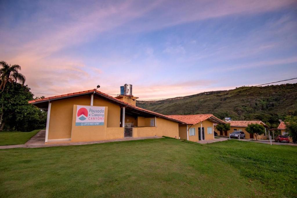 a building with a sign on the side of it at Canyons Camping Capitolio in Capitólio