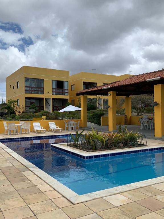 un resort con piscina attrezzata con tavoli e sedie di flat condomínio paraíso da serra negra - bezerros - PE a Bezerros