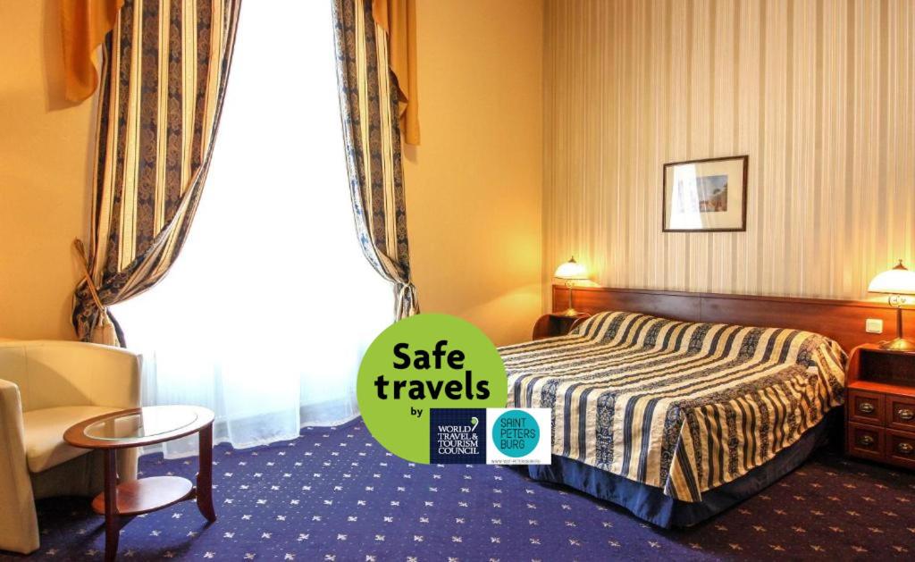 una habitación de hotel con una cama y un cartel que dice que viaje seguro en Belvedere Nevsky Business Hotel, en San Petersburgo