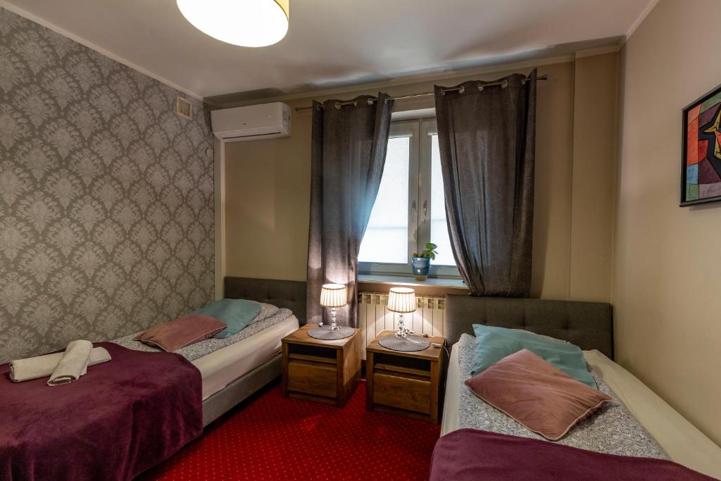 sypialnia z 2 łóżkami i oknem w obiekcie Villa Kava w Warszawie