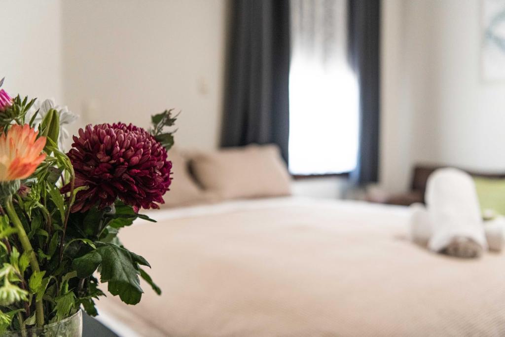 a vase with flowers on a table in a bedroom at New Crown Hotel Motel in Hay