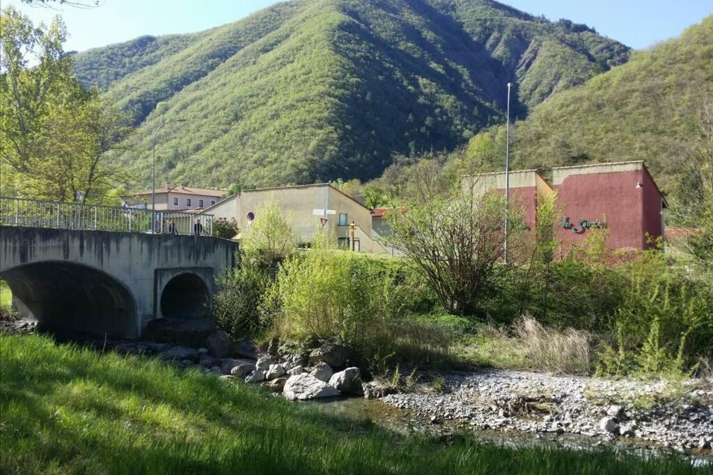 a bridge over a river with a mountain in the background at Jolie T2 N°1 Résidence du Vallons des Sources in Digne-les-Bains