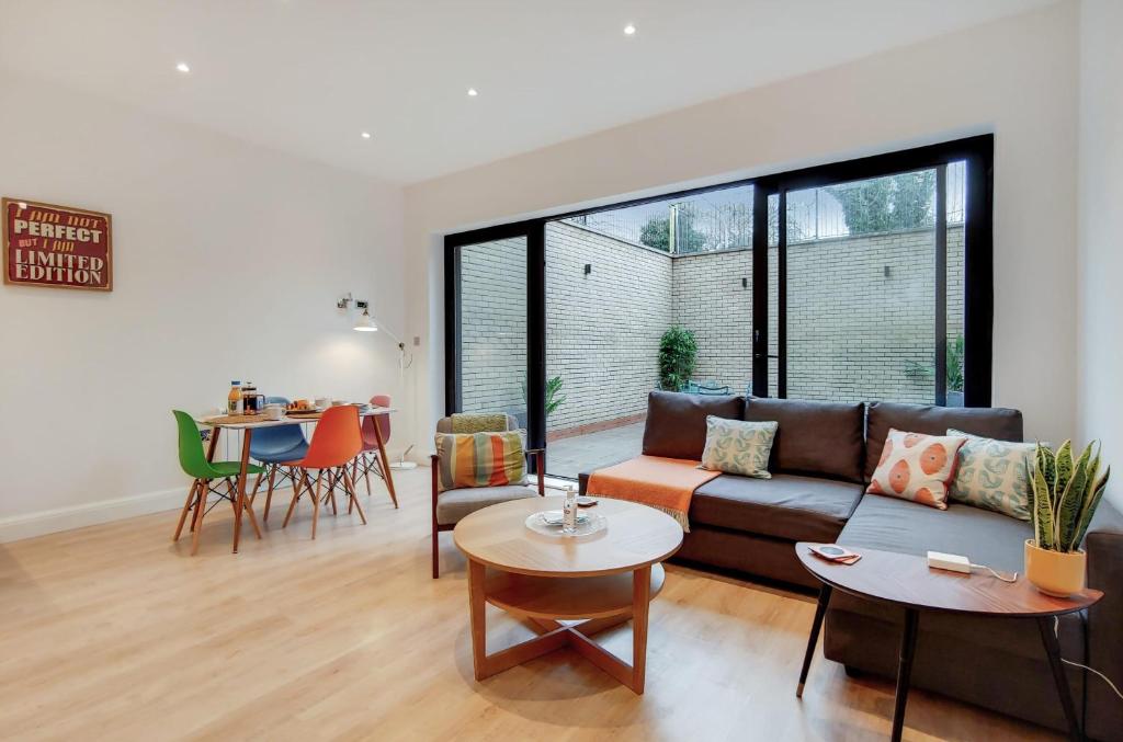 a living room with a couch and a table at Modern Ealing Apartment with Large Private Patio in London